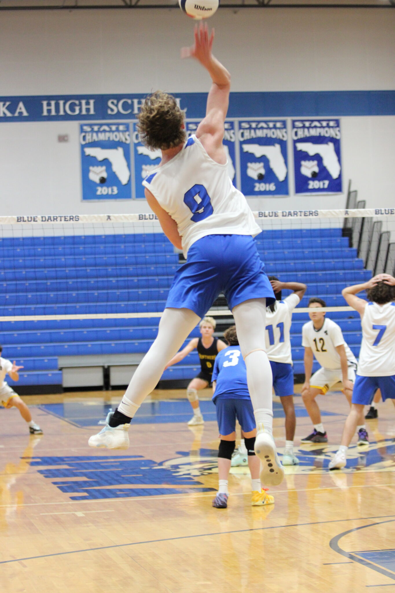Caden McGatha sends a booming serve over the net to Forest Lake Academy
