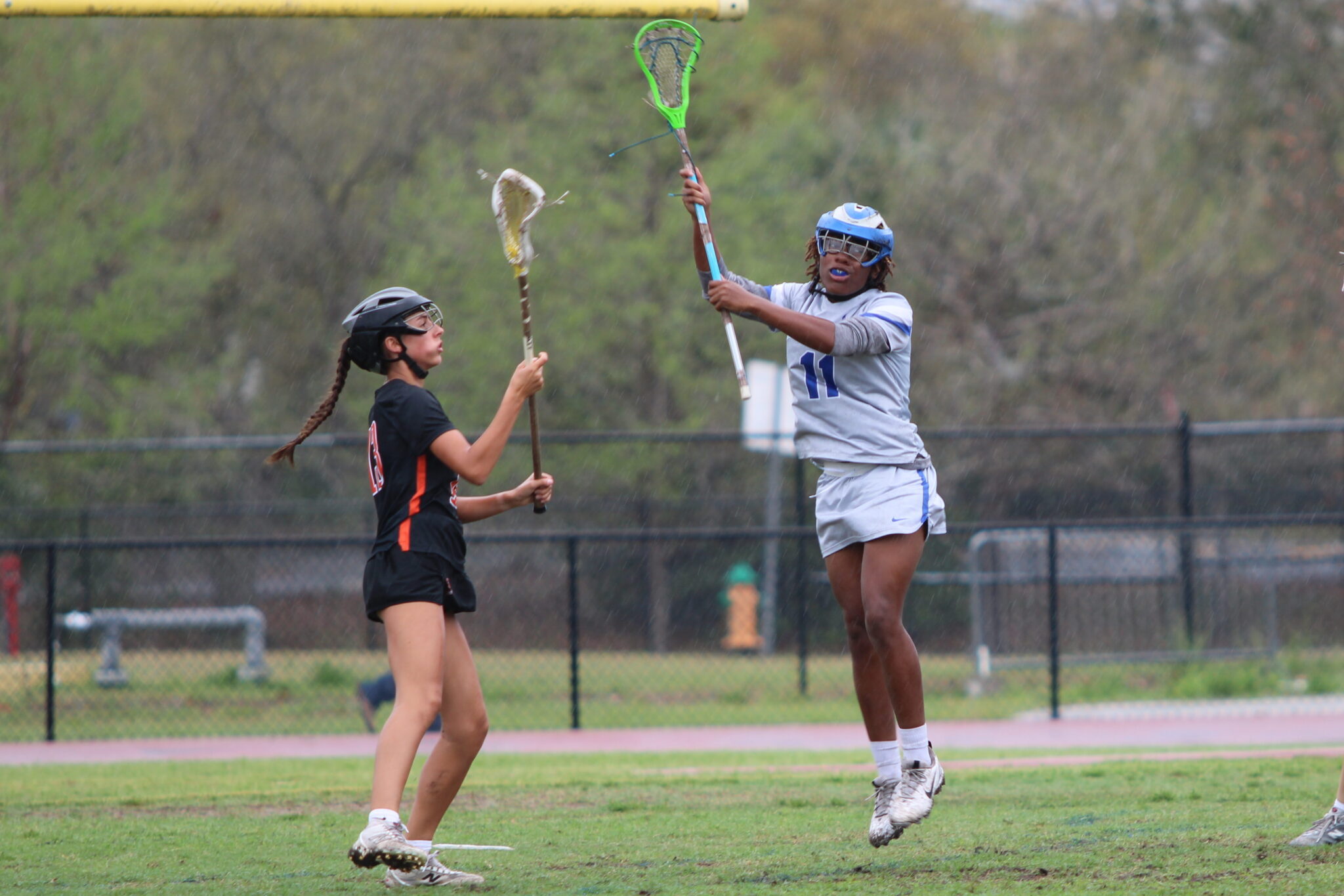 Cailyn Anderson leaps and lifts her stick in attempt to stop the Seminole pass