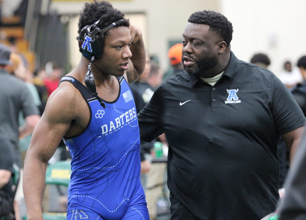 Coach James Harris talks with Marcus Young after his win in the first round of the regional tournament