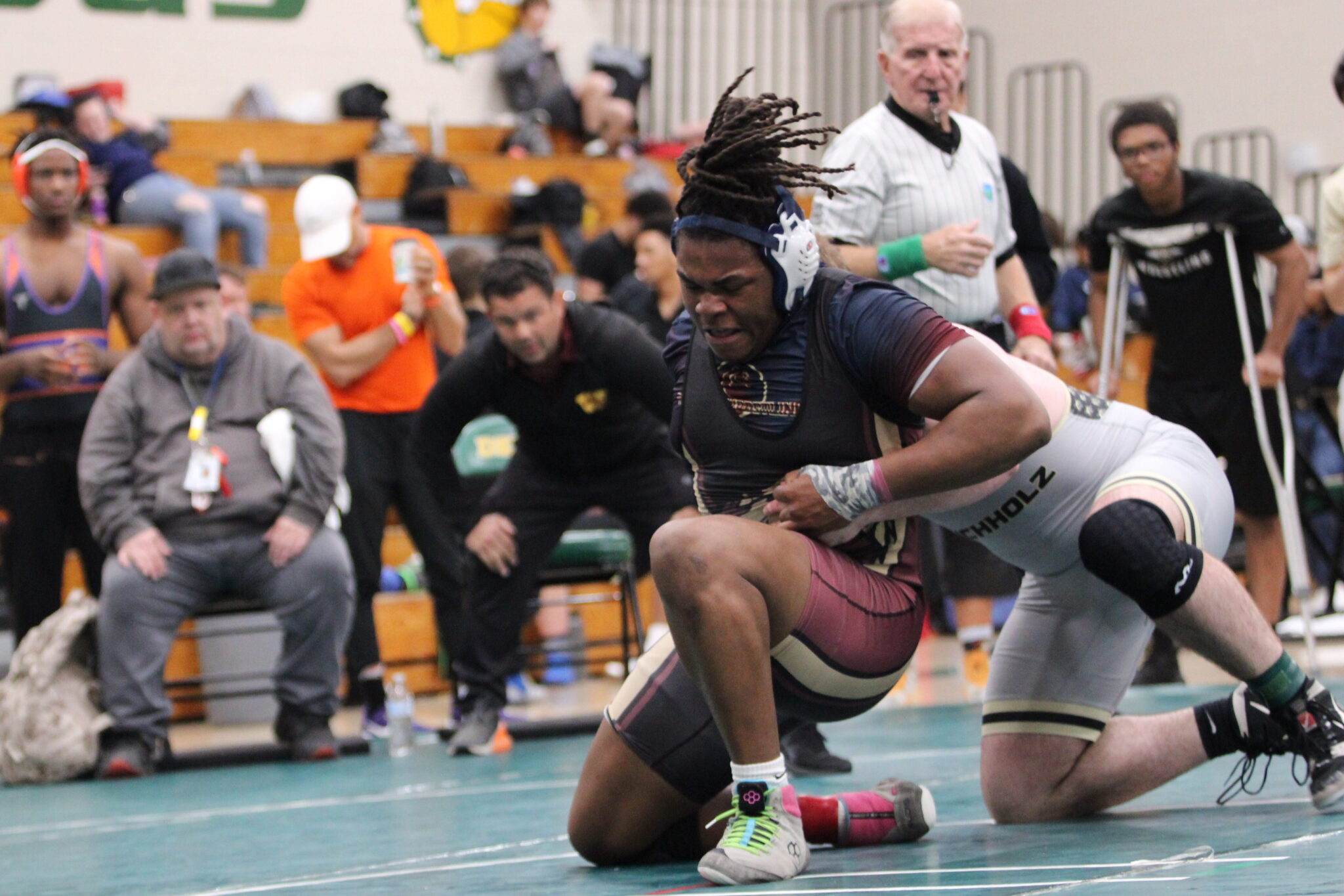 Elijah Jean explodes upward to escape Bucholz hold for a point in the consolation quarterfinals at the regional tournament