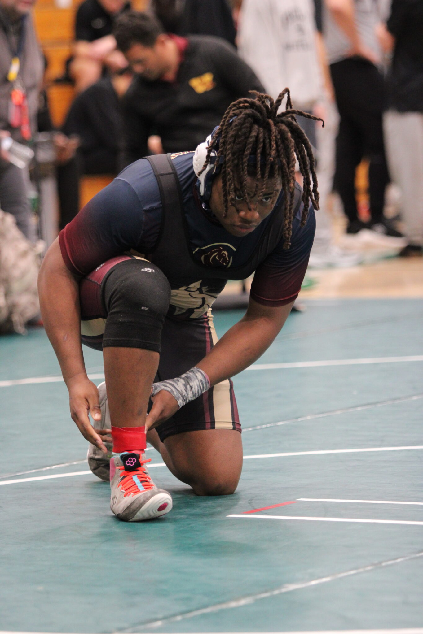 Elijah Jean straps up the red band as he locks in for his consolation quarterfinal