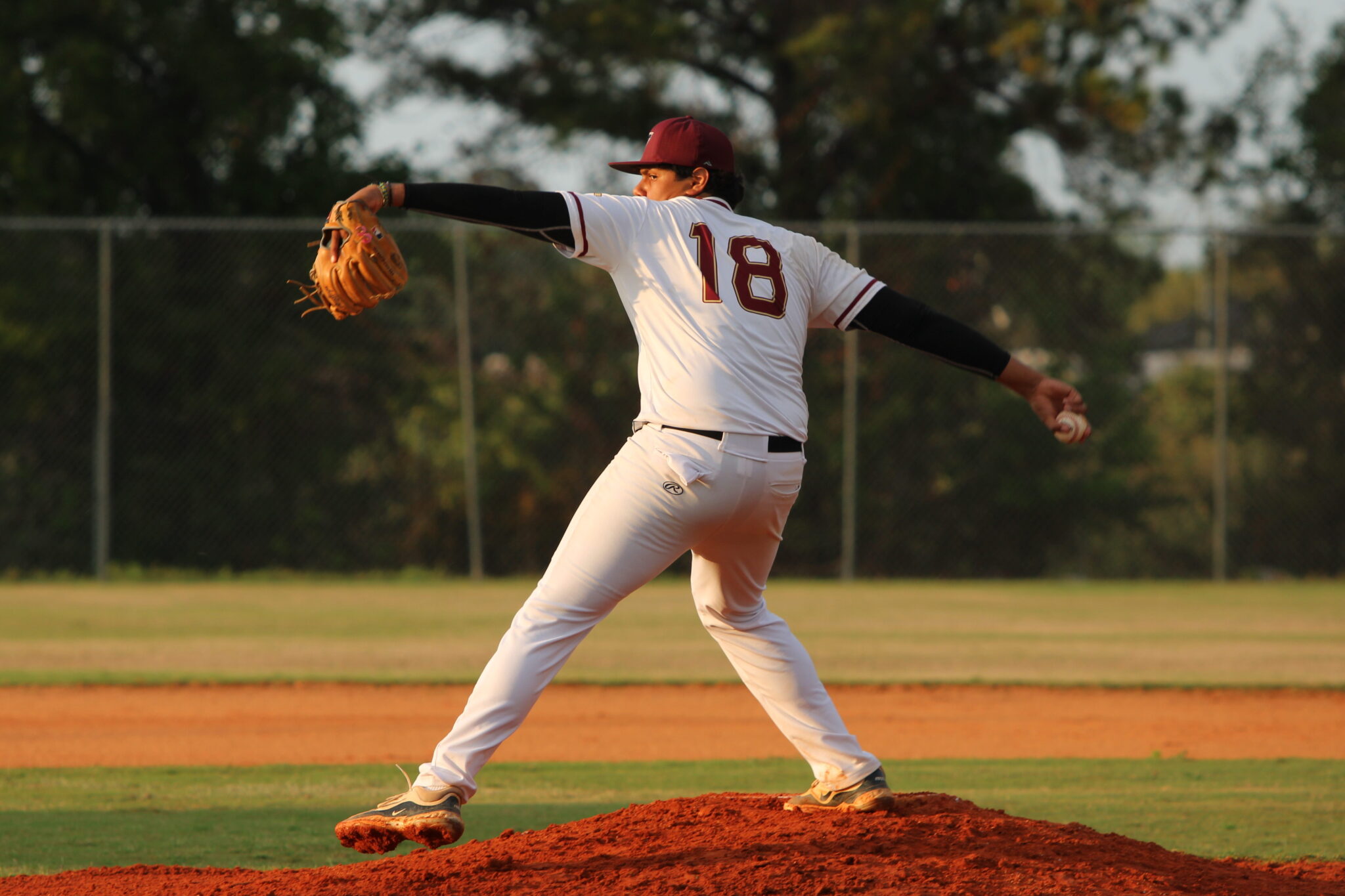 Emil Flaquer winds back to whip in a pitch against Liberty
