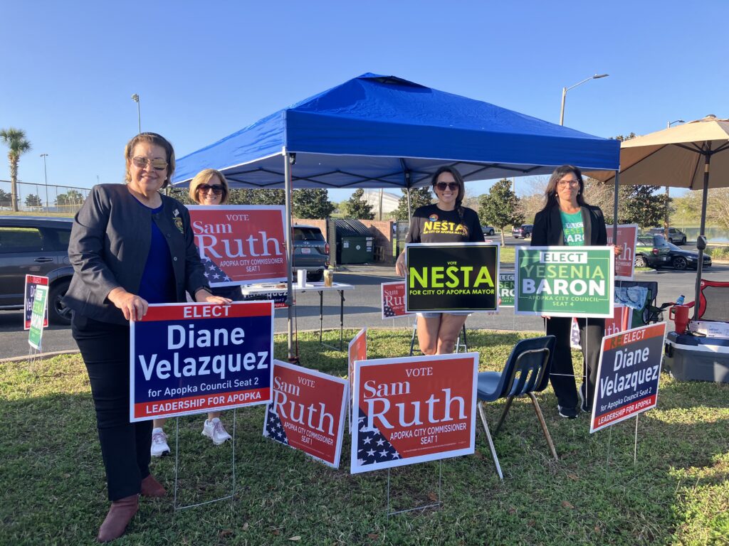 Candidates, including Council Seat 2 incumbent Vice Mayor Diane Velazquez (L) and Council Seat 4 challenger Yesenia Baron (R), encourage voters to cast their ballots Tuesday at the Northwest Recreation Complex.