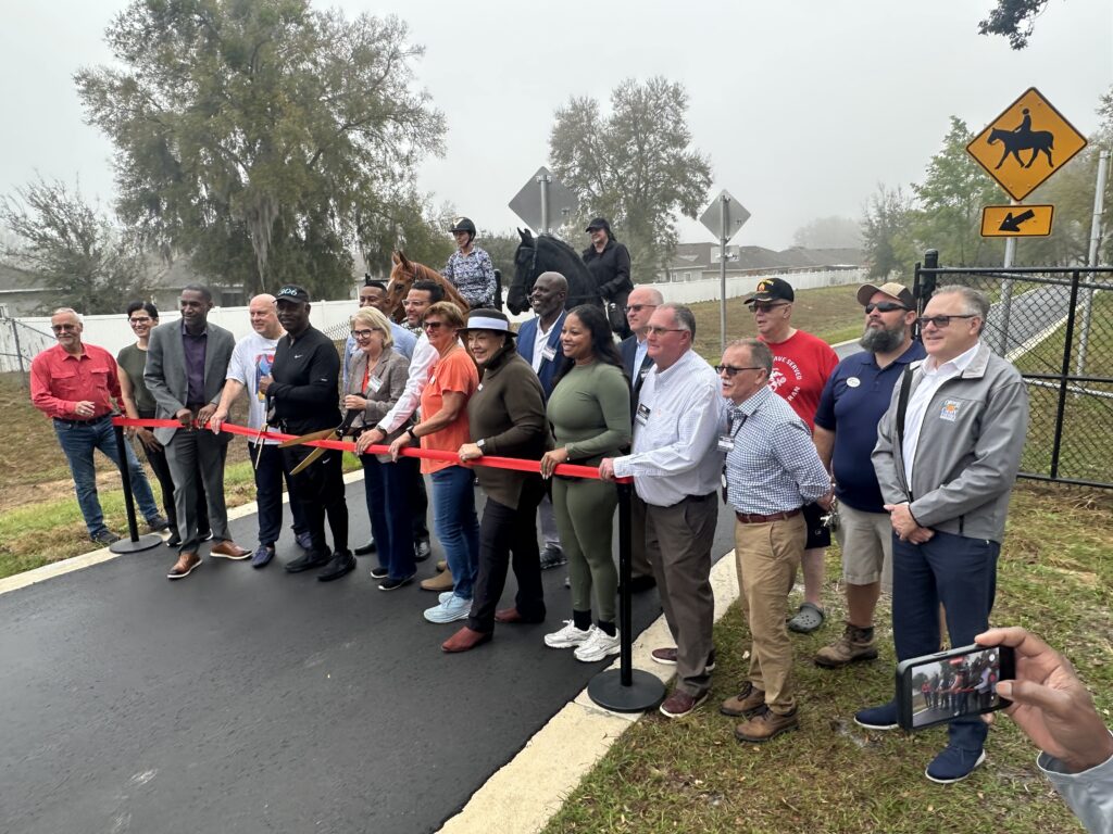 Community members and local leaders gather to cut the ribbon on the Lake Apopka Connector Trail, a $10.2 million project stretching 4.46 miles from Magnolia Park to Clarcona Horse Park in Apopka, and includes a 10- to 14-foot wide multi-use path with a boardwalk section.