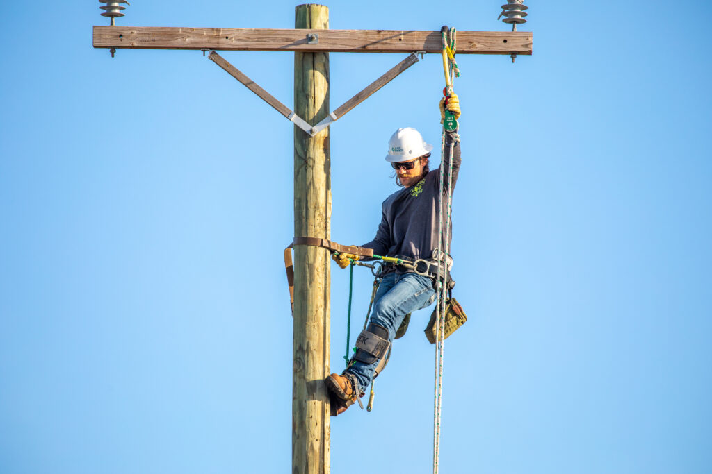 Jeremy Neumann hangs from a utility pole.