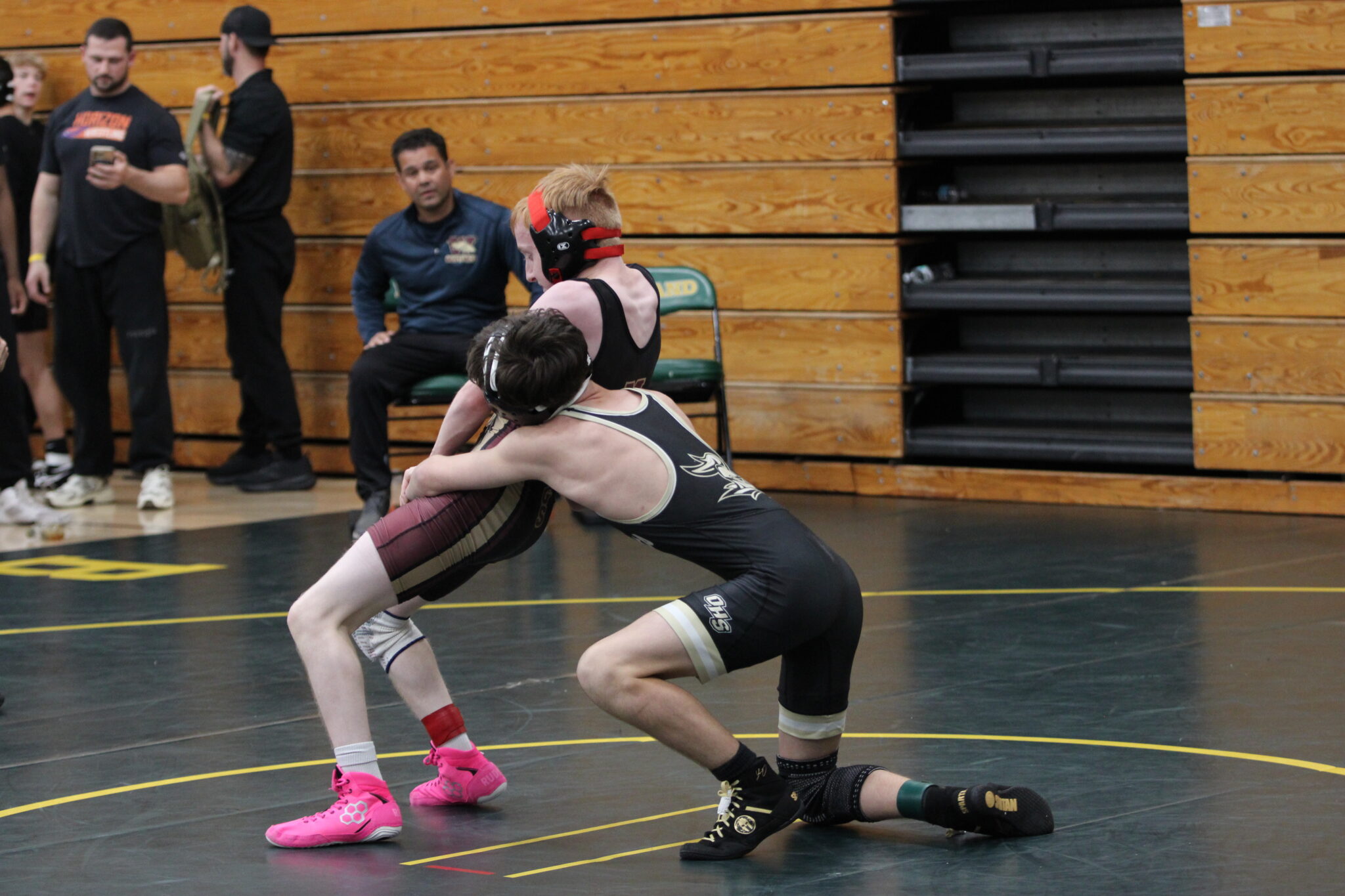 Landonn Shultz stands up and leans back to break the hold of his consolation round opponent from Oakleaf