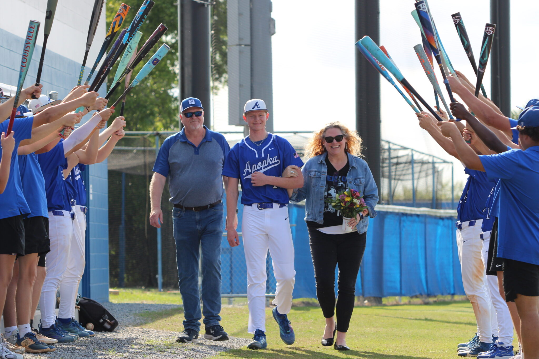 Logan Page walks out with his mother and father on senior night