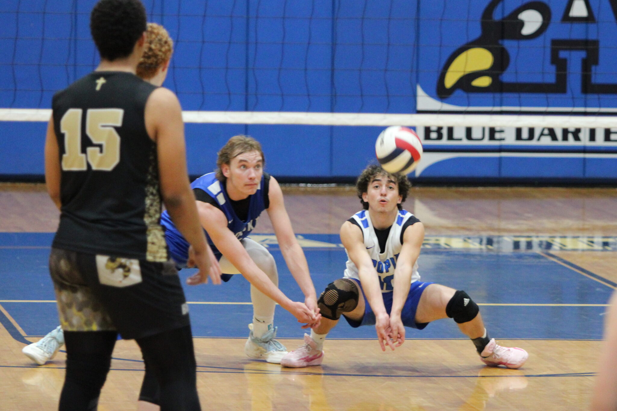 Renzo Polar and Caden McGatha dig out a ball dropping to the floor