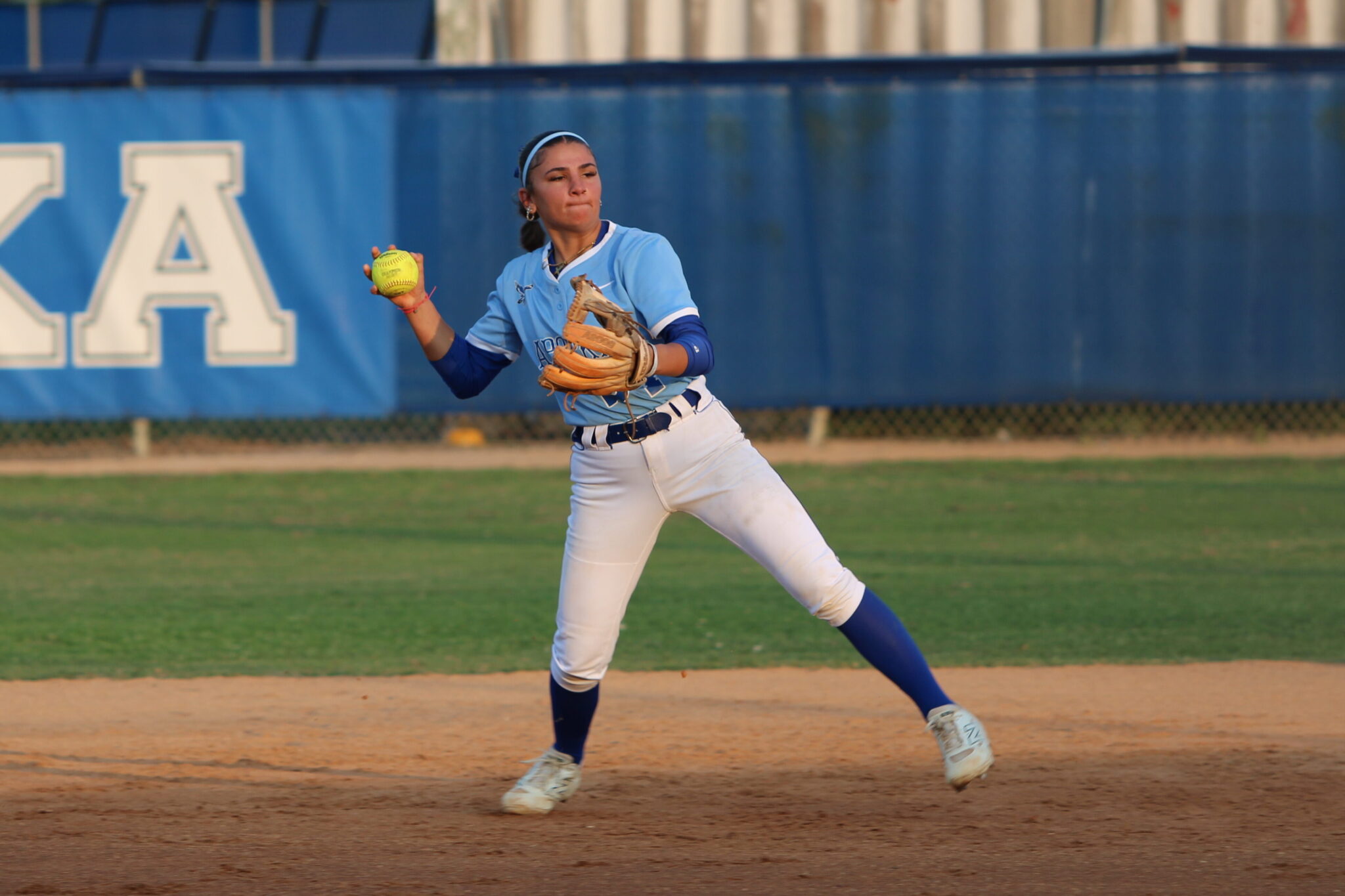 Shylah Pino at fields a ball at shortstop and throws the runner out at first