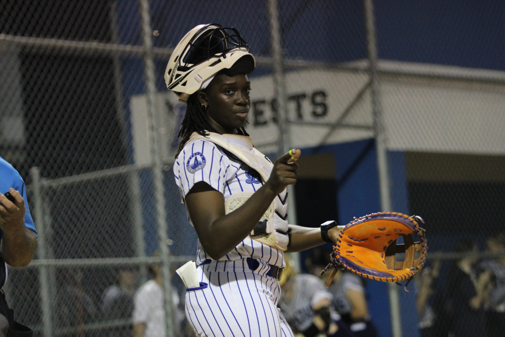 Taylor Smith behind the plate, looks to the dugout and Coach MacWithey for the plan