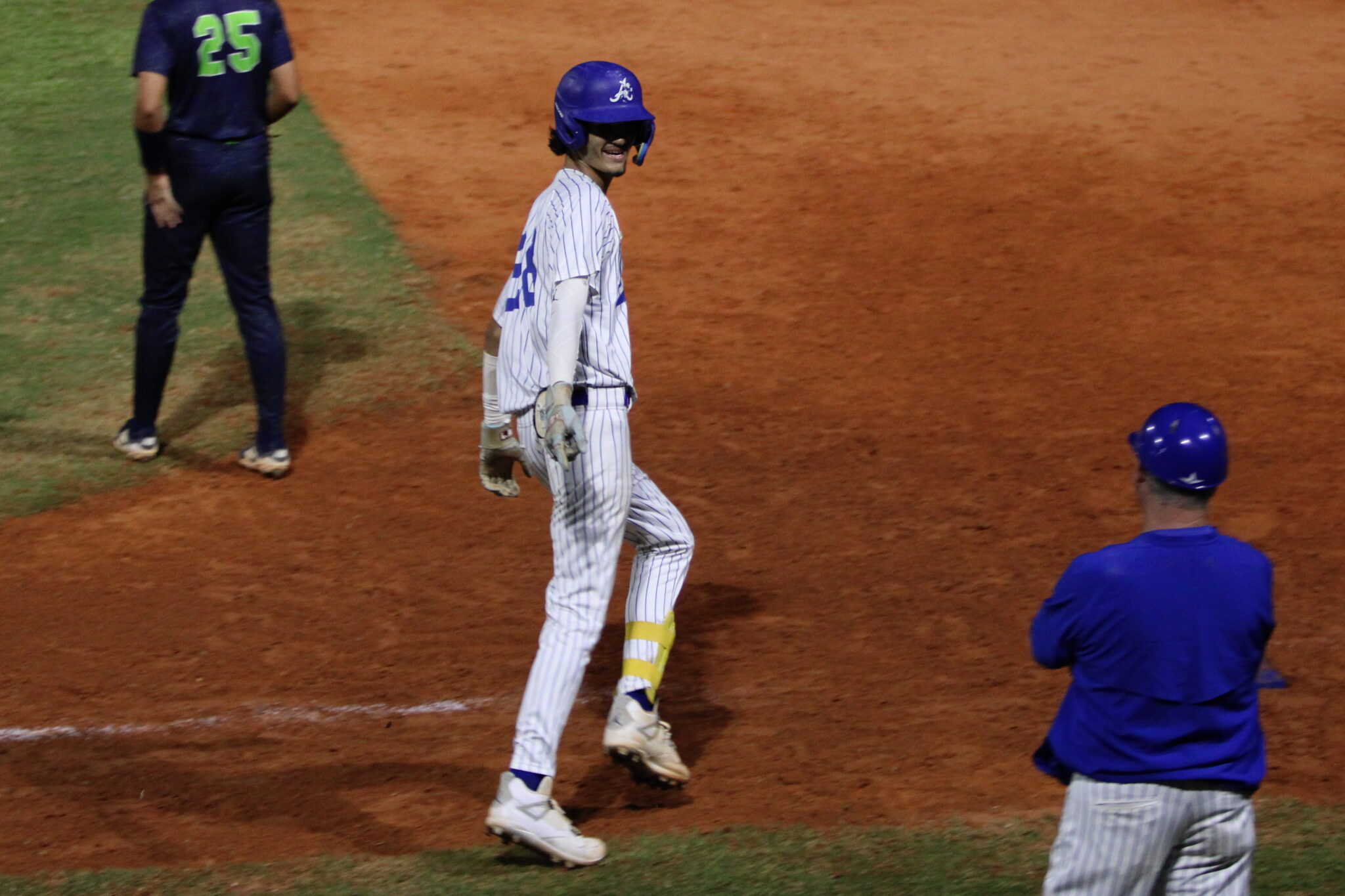 Tyler Spaid rounds first base and points to his coach after his blistering homerun over the left field fence