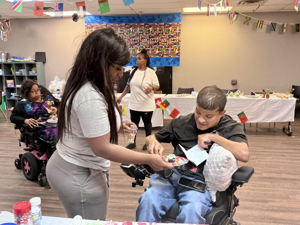 A volunteer helps a participant near the United Kingdom dessert station.