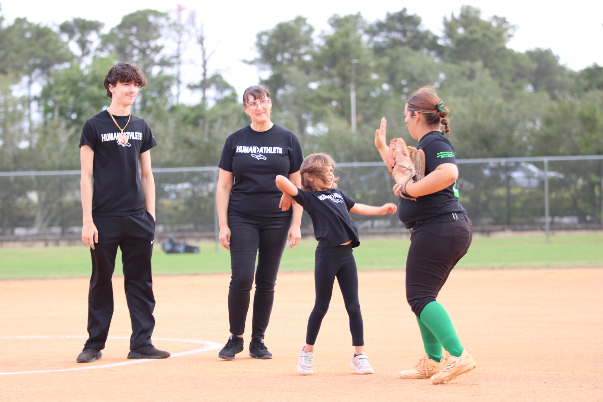Amanda Crofton's daughter and Arianna Garcia high-five after the first pitch