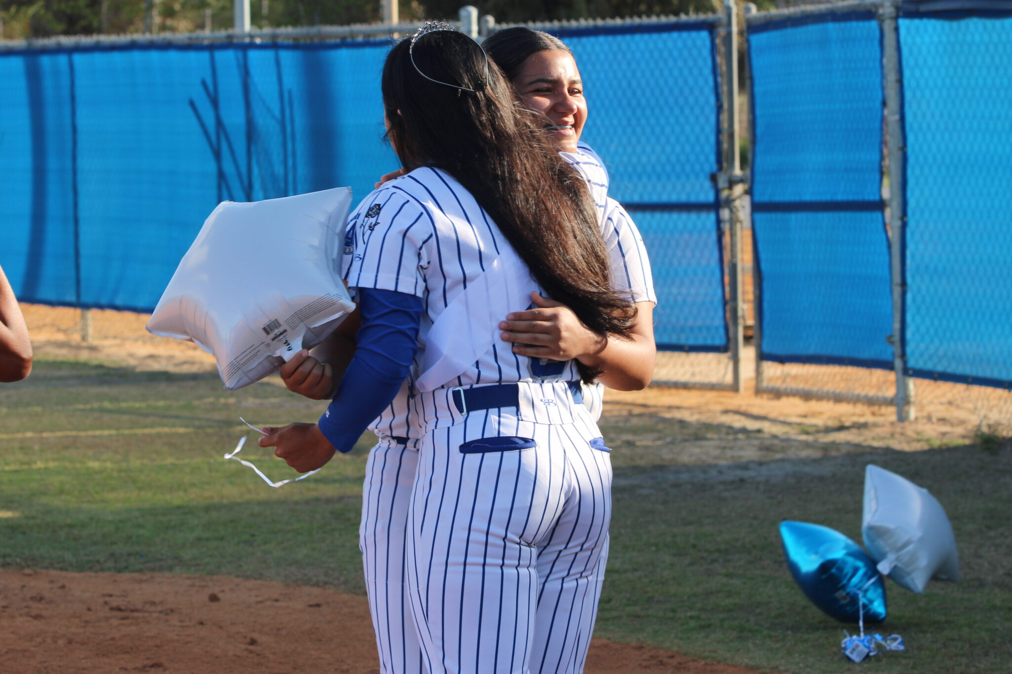 Anamarie Lopez greets her senior sister Alicia Lopez at first base