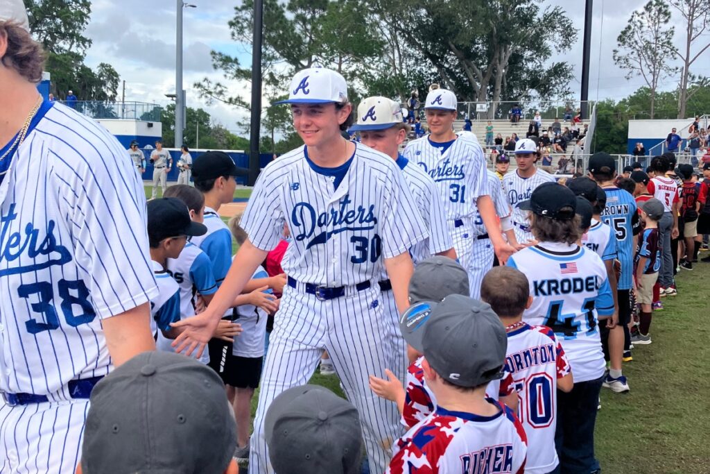 Apopka Blue Darters players ran onto the field through two lines of Little Leaguers.