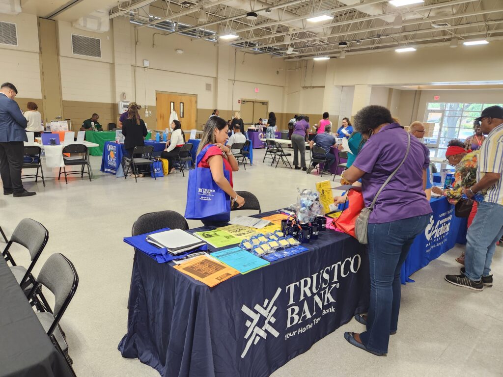 Attendees of last year's resource fair gather at Trustco Bank's table.