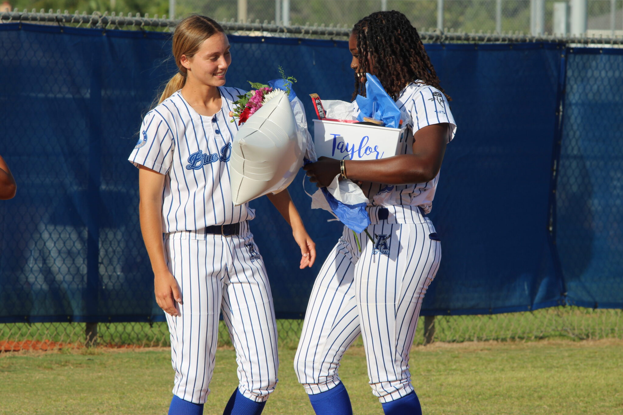 Ava Gonzalez greets Taylor Smith at third base with a gift basket