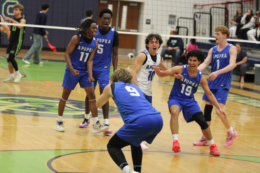 Blue Darters get hyped up after Cade McGatha's serve pins the surface late in the fifth and final set