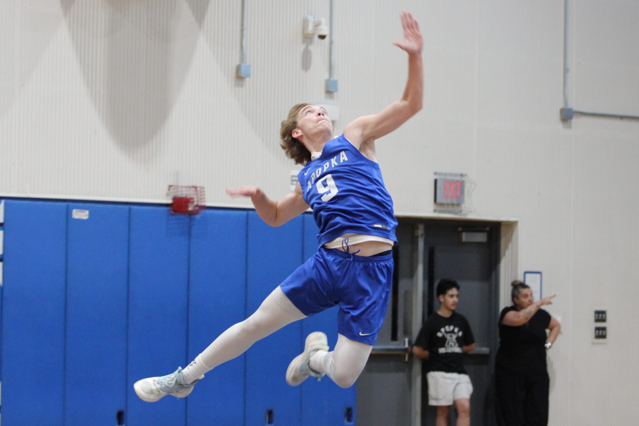 Caden McGatha goes full extension for the first serve of the game