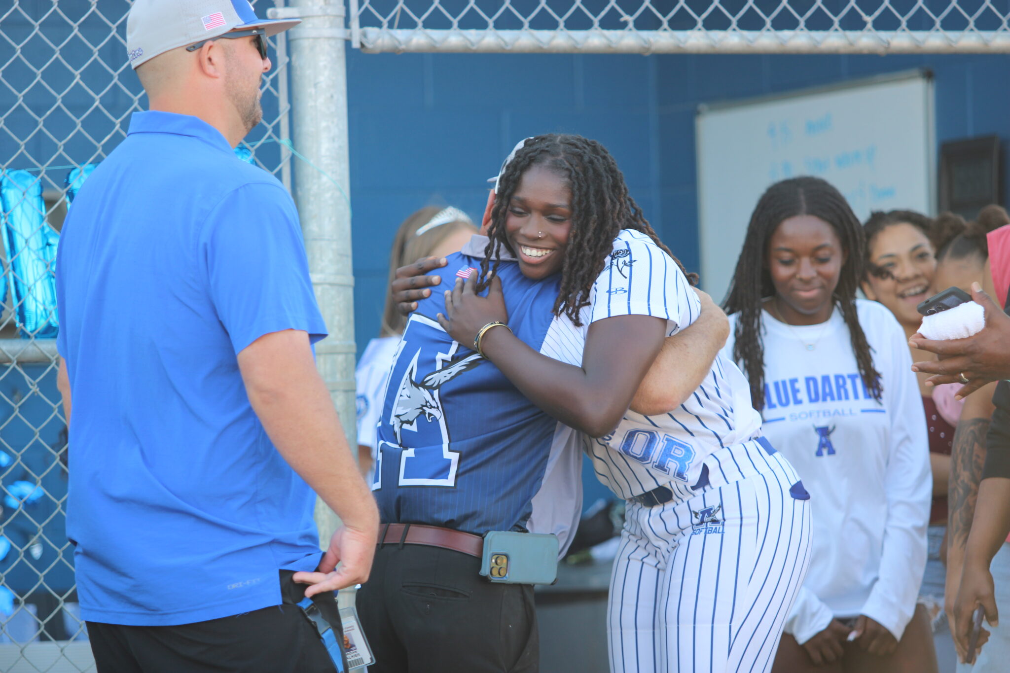 Coach Mike MacWithey and Taylor Smith share a hug as she walks out for senior night