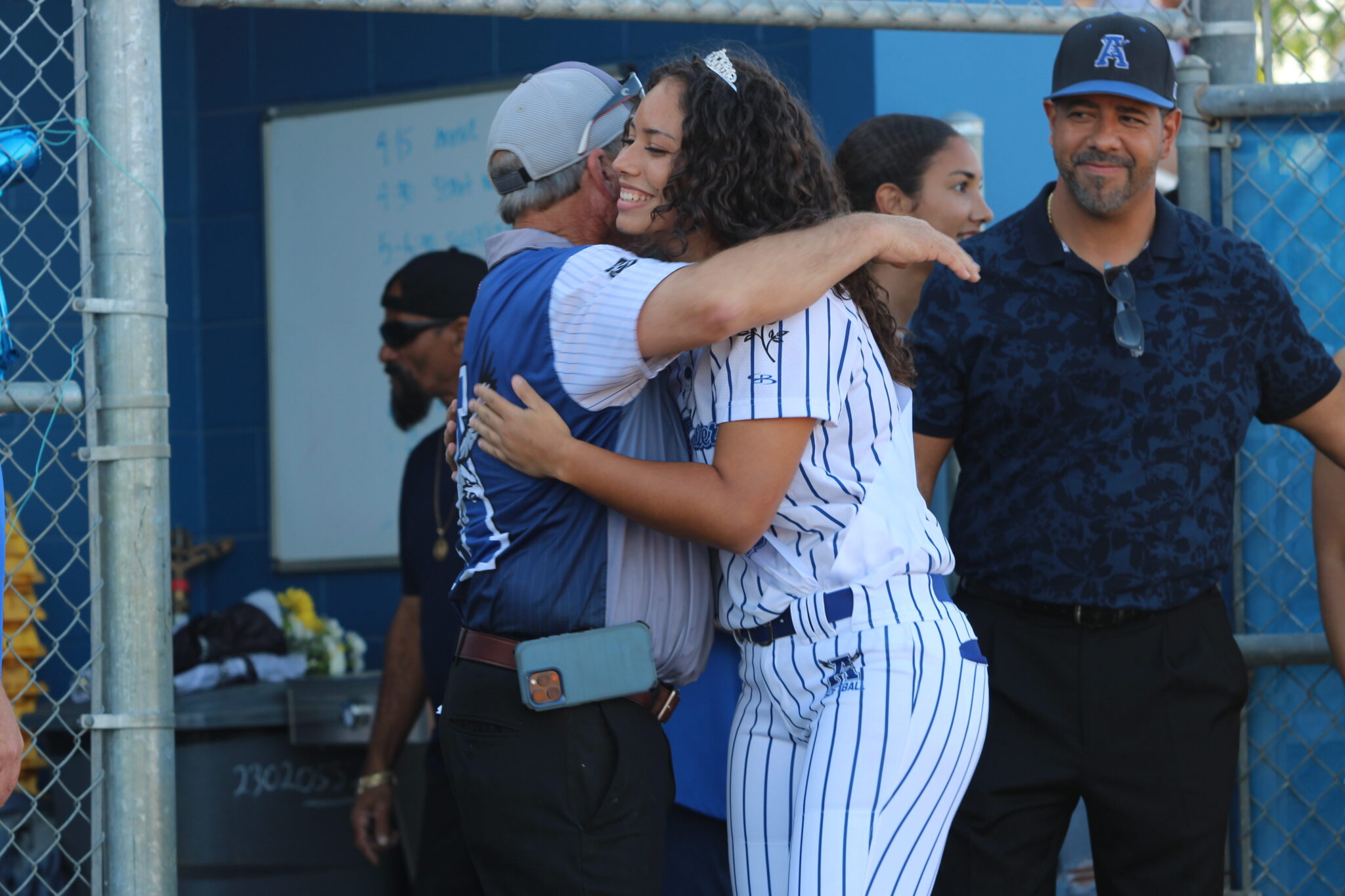 Coach Mike MacWithey and Victoria Shaw share a hug as she walks out for senior night