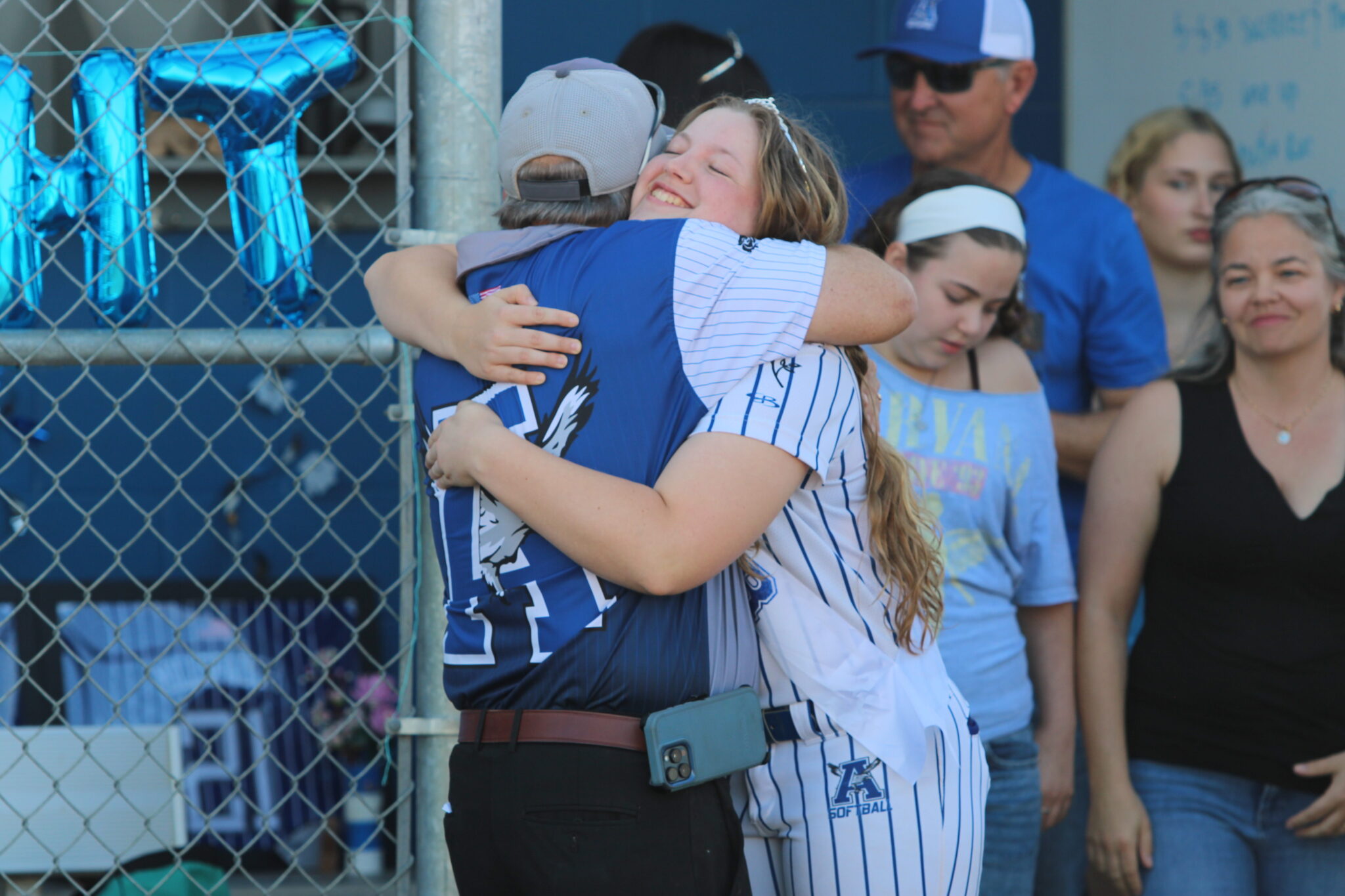 Coach Mike MacWithey greets Alezia Hatcher with a hug on senior night