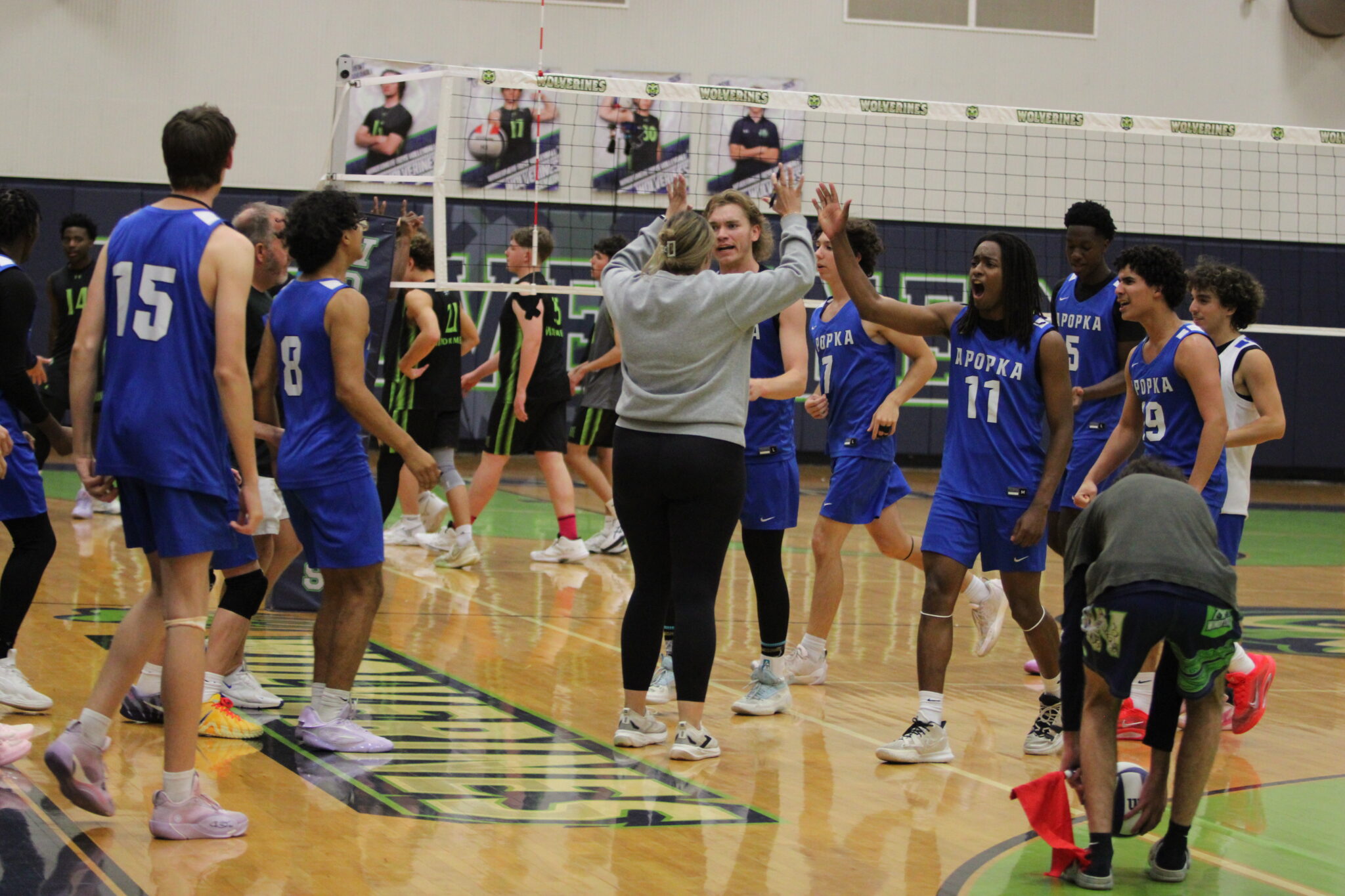 Coach Sarah Egbers high fives her players after a great first set win