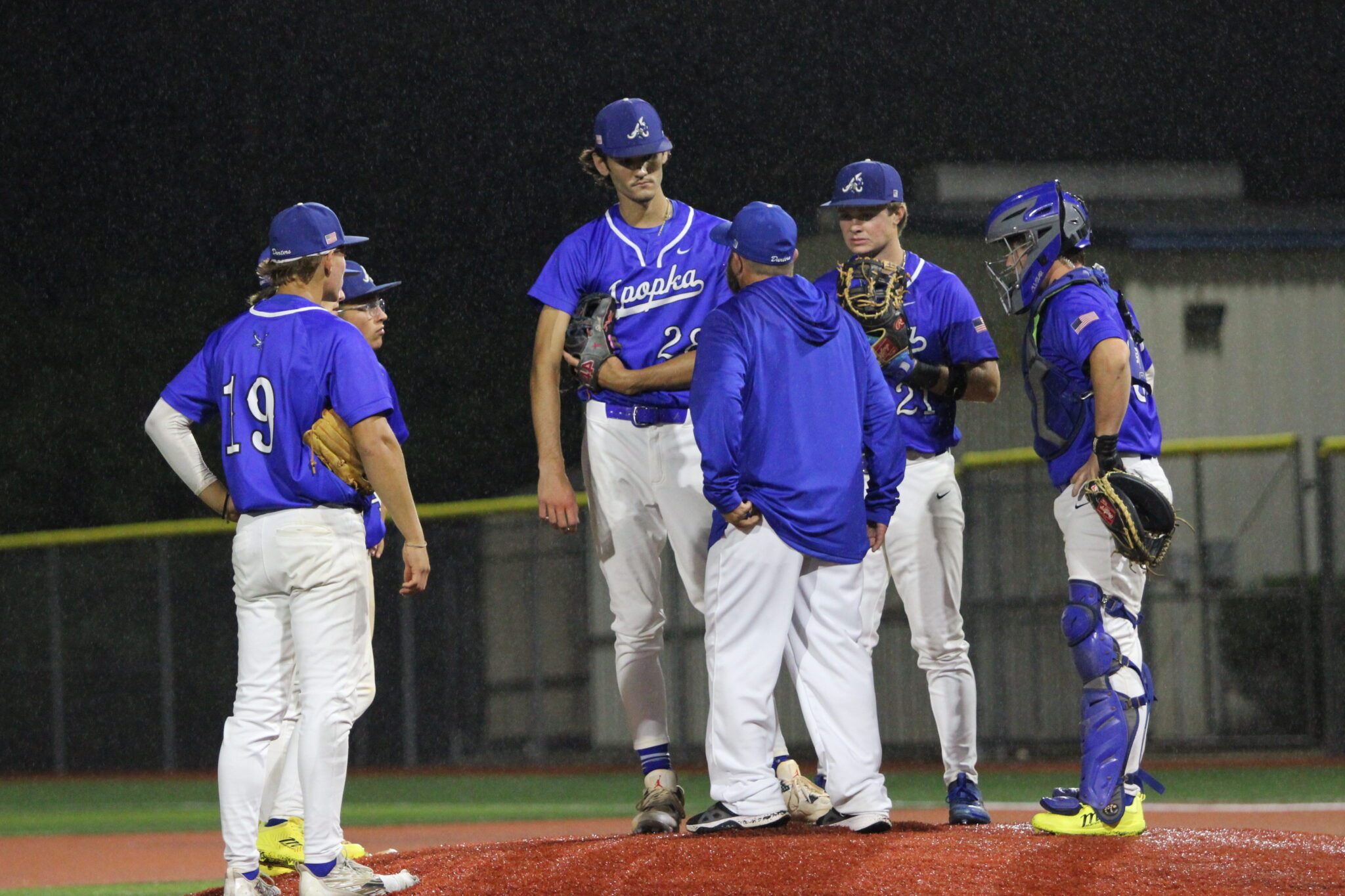 Coach Scott Garland heads to the mound to talk to Tyler Spaid and the infield