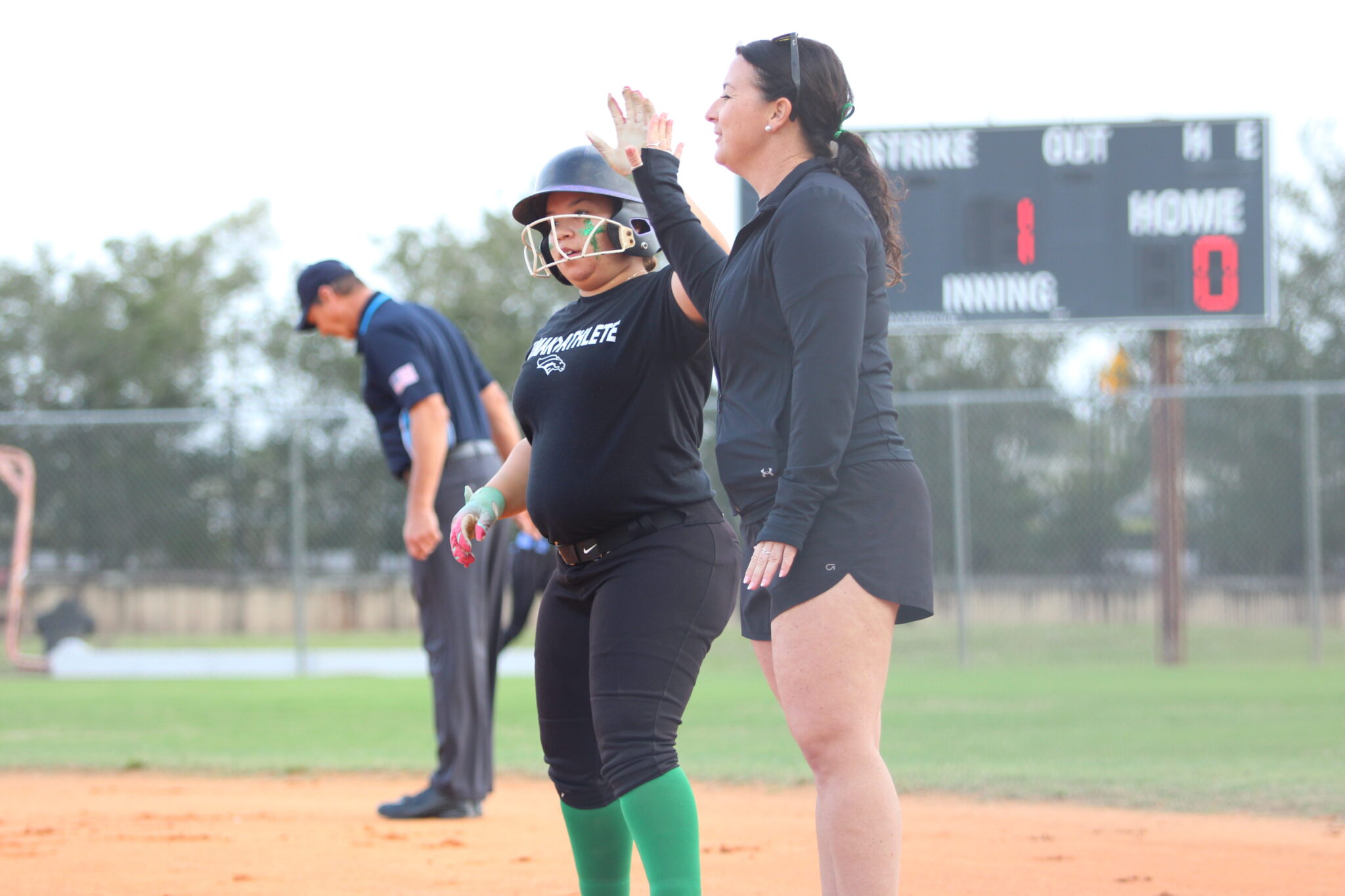 Coach Taylor McGowan meets Arianna Garcia at first after her hit