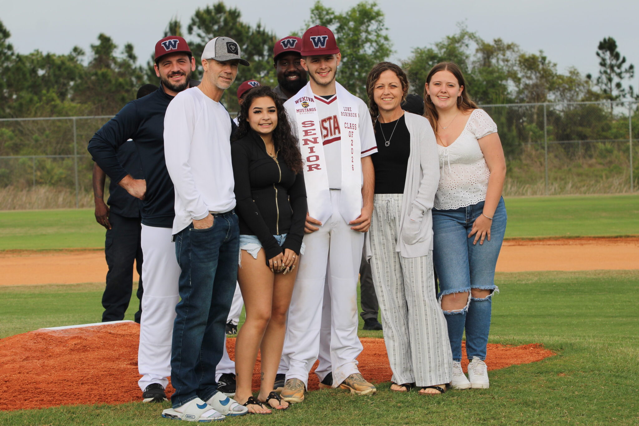Luke Robinson poses with his family and coaches for senior night