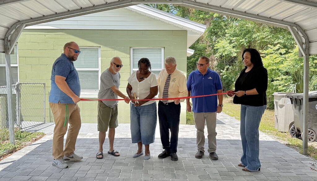 Marilyn Perkins cuts the ribbon for her newly renovated home at 407 E. Eighth St.