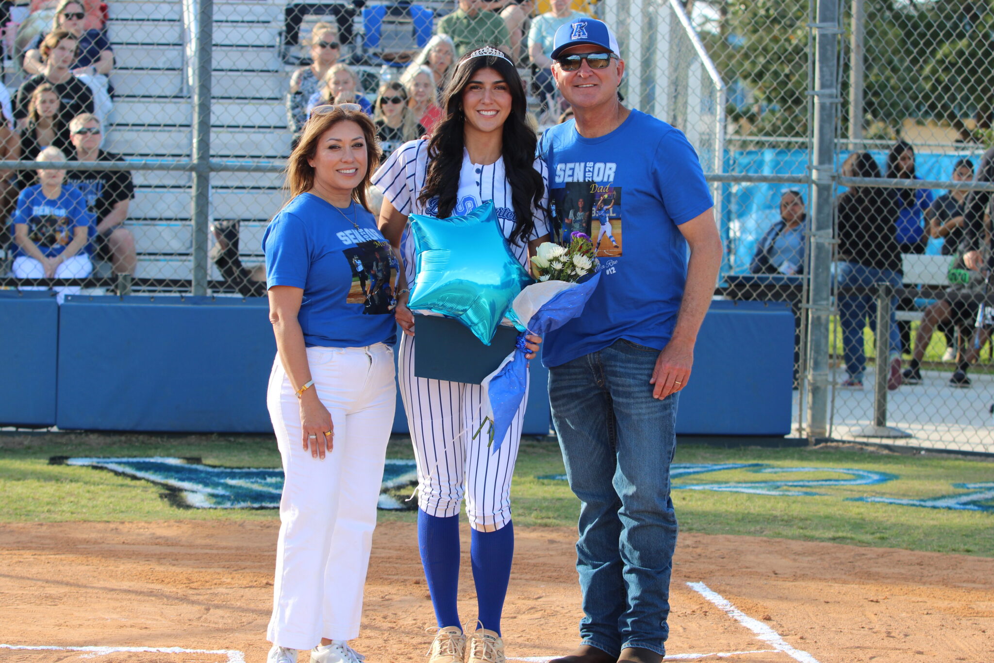 Mia Aeschilman poses with her mother and father on senior night