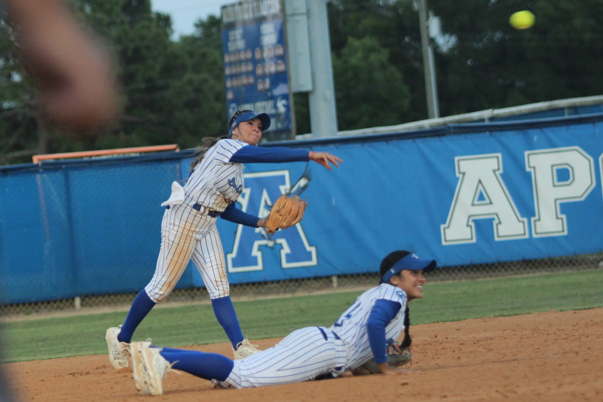 Shylah Pino backs up Alicia Lopez's dive attempt at a groundball, and guns the ball to first