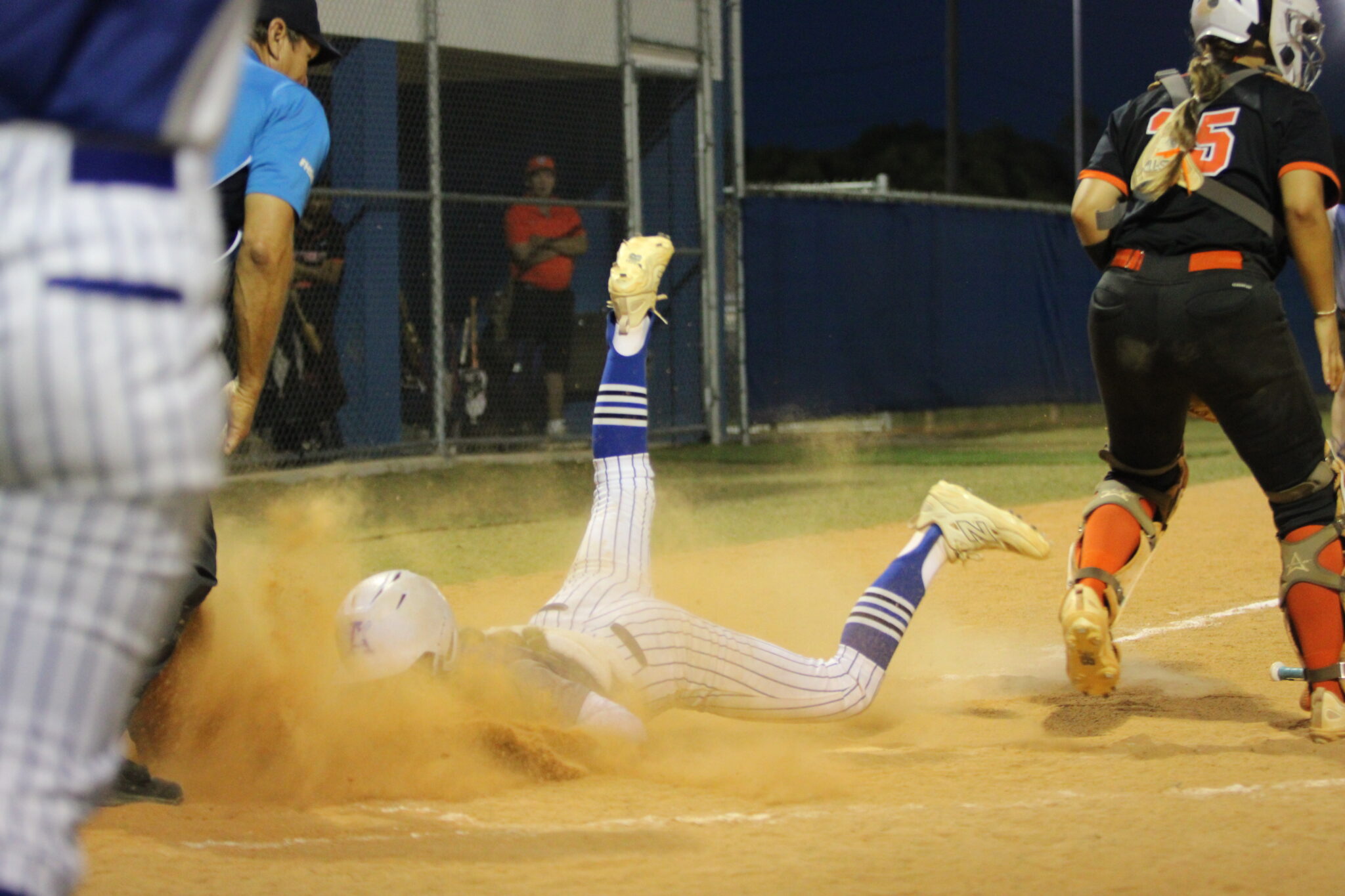 Shylah Pino dives into home plate head first and gets a faceful of dirt against Seminole