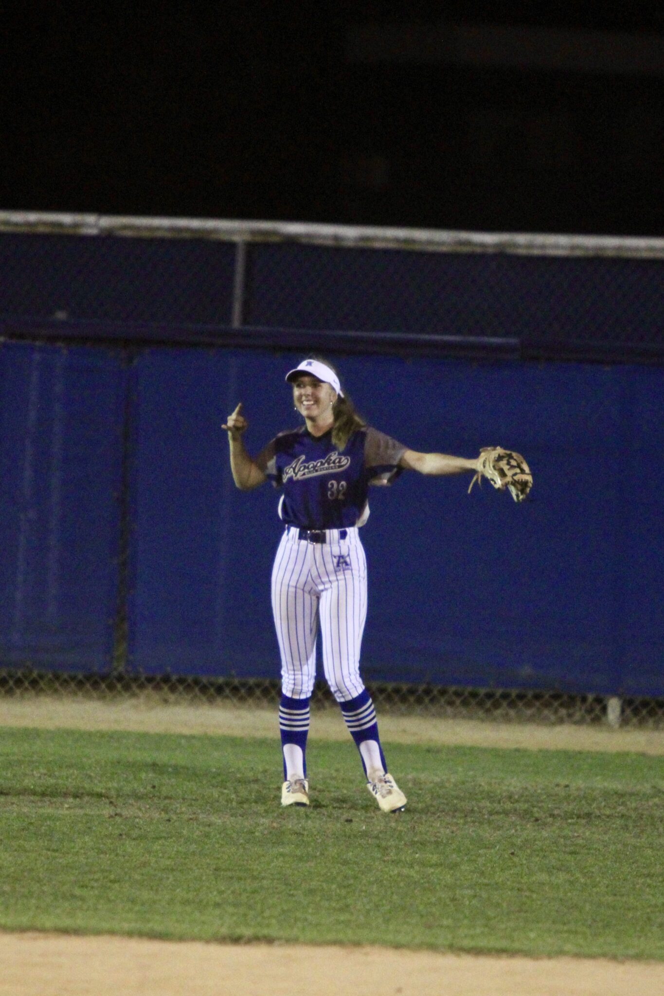 Sydney Bartkin releases the bow and arrow celebration after throwing a strike from centerfield to home plate to gun out a runner