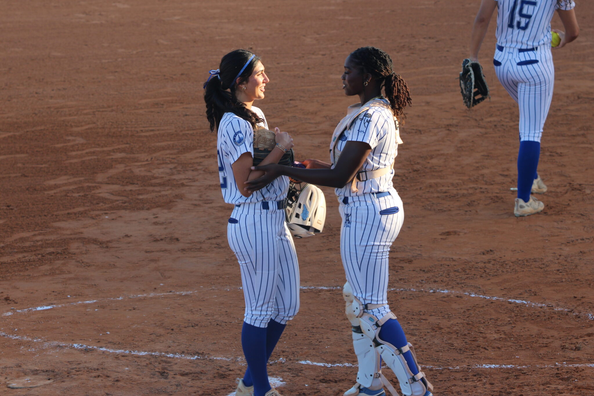 Taylor Smith and Mia Aeschilman share a moment before she pitches the first inning