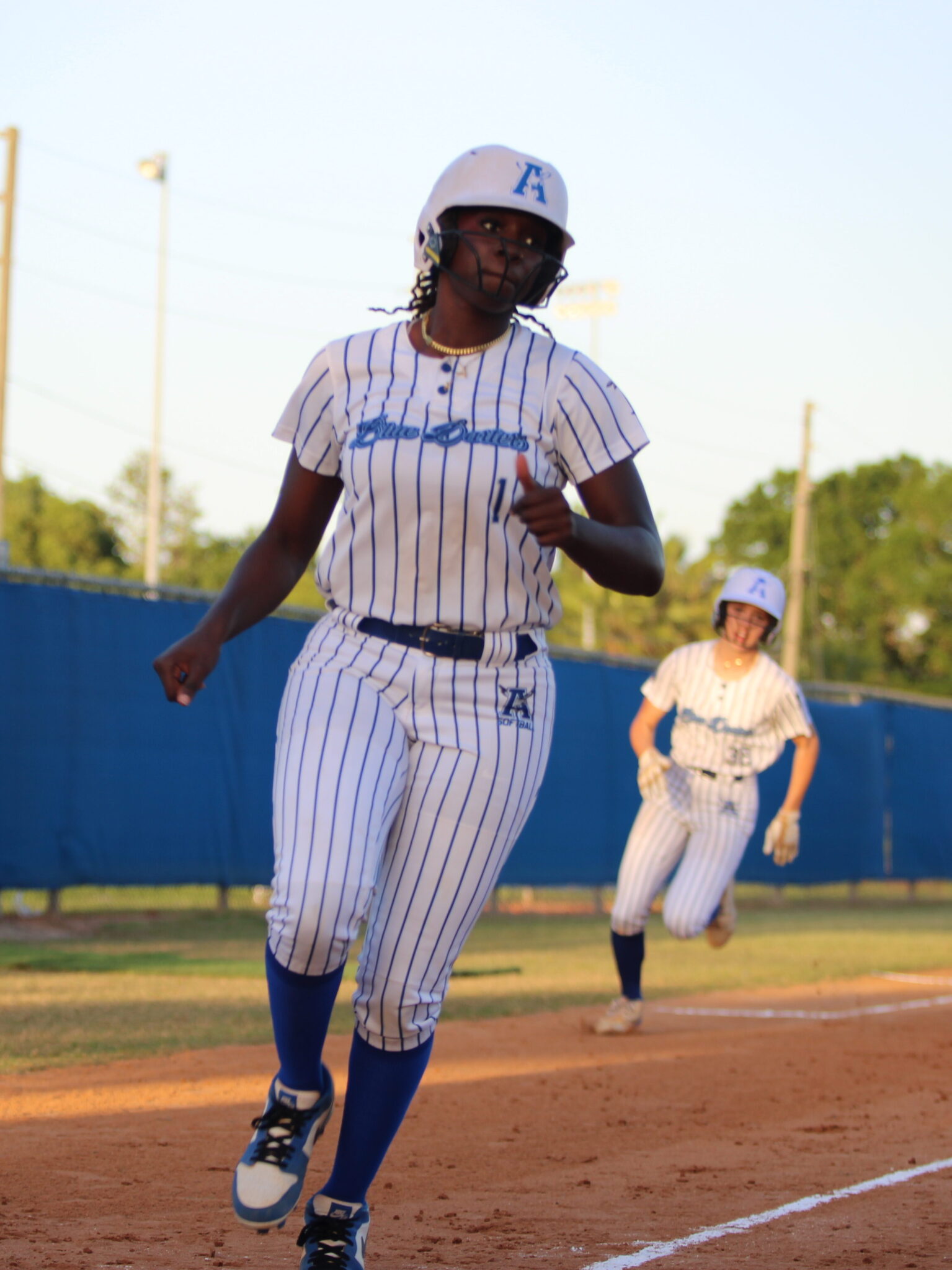 Taylor Smith runs across home plate with Sydney Bartkin right on her tail in the first inning