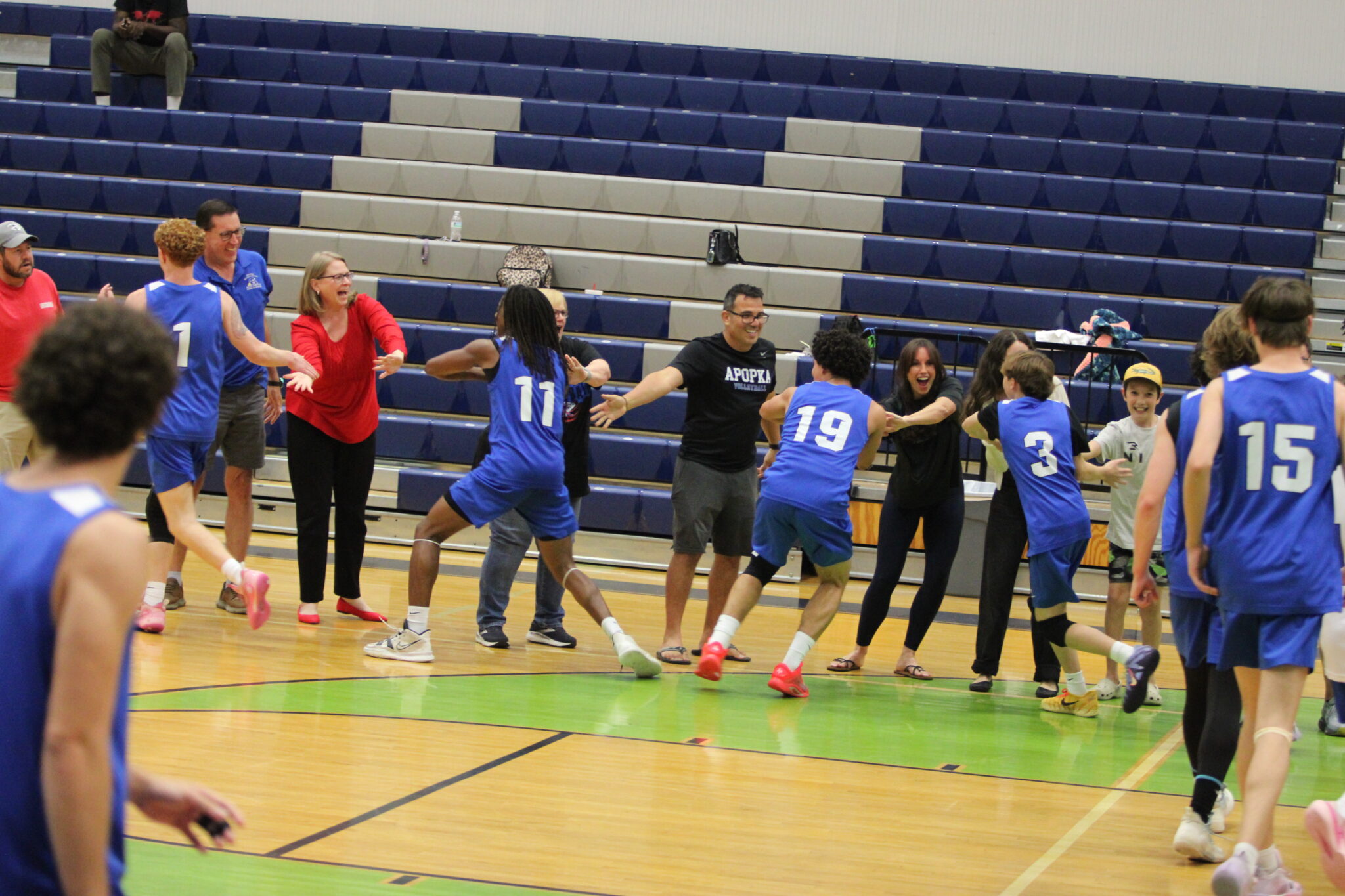 The traveling Blue Darter crowd and Blue Darter volleyball players show love to each other after the big semifinal win in Windermere