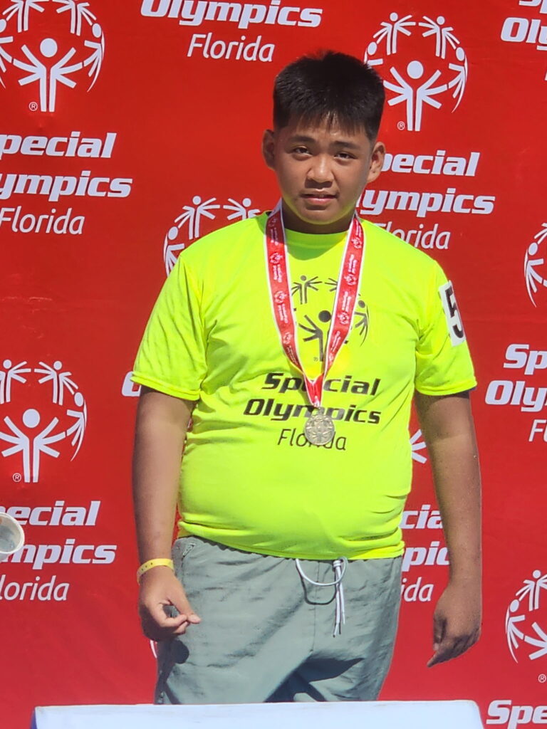 Mark Delfino poses with his medal at the Florida Special Olympics.