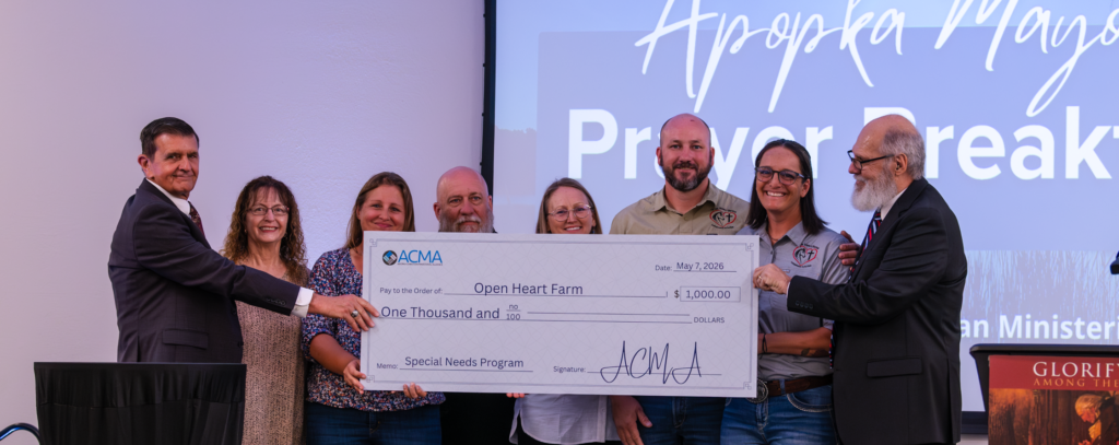 The Apopka Christian Ministerial Alliance (ACMA) presents Open Heart Farms with a $1,000 check at the Thursday breakfast.