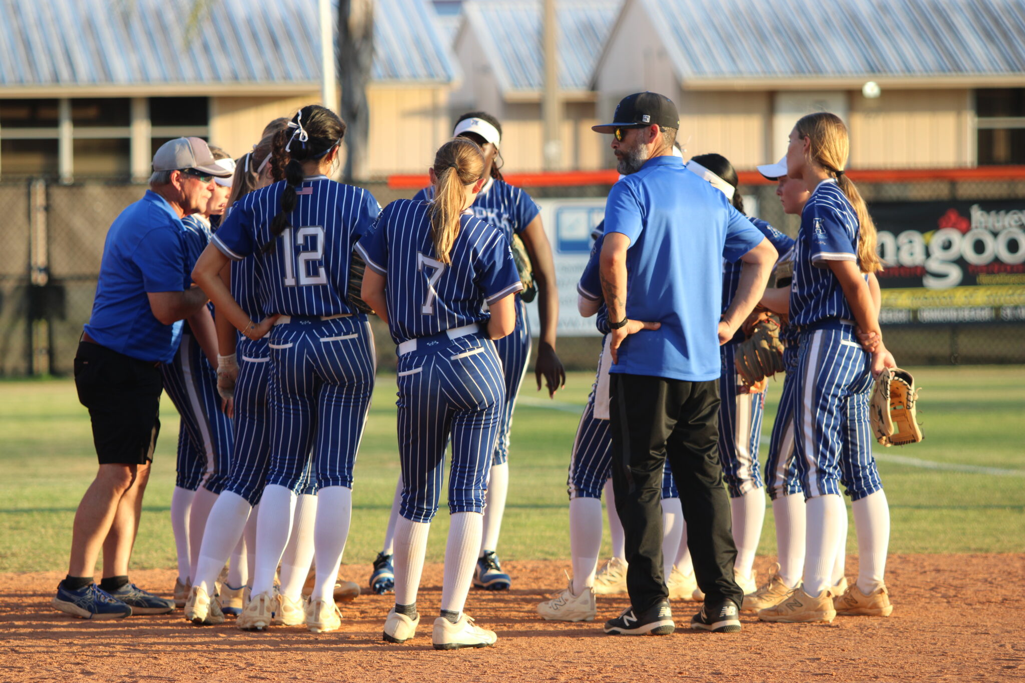 Blue Darters huddle after the third inning to try and rally some hits.