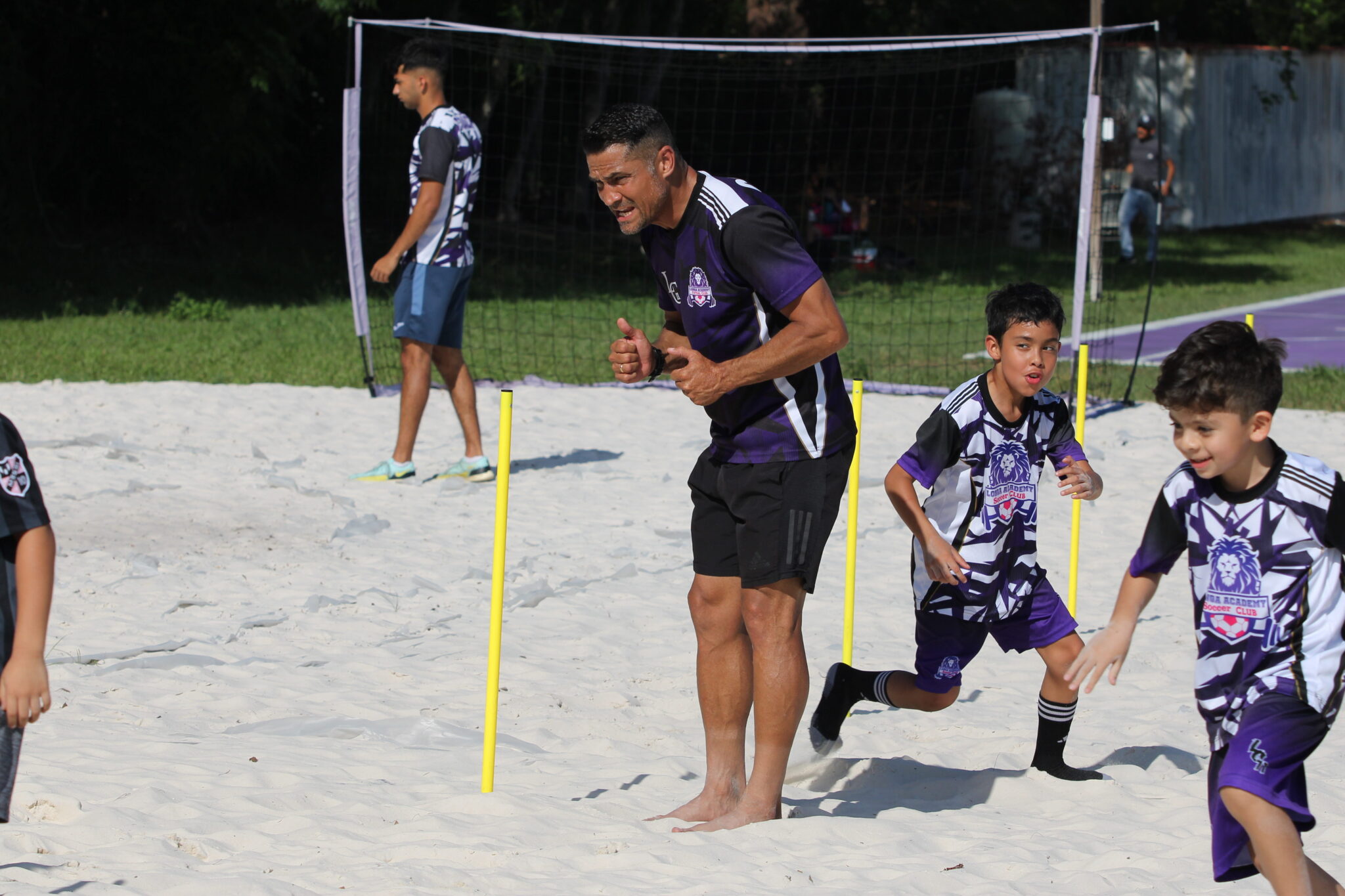Coach Carlos Longa gives a player a thumbs up during a training drill.