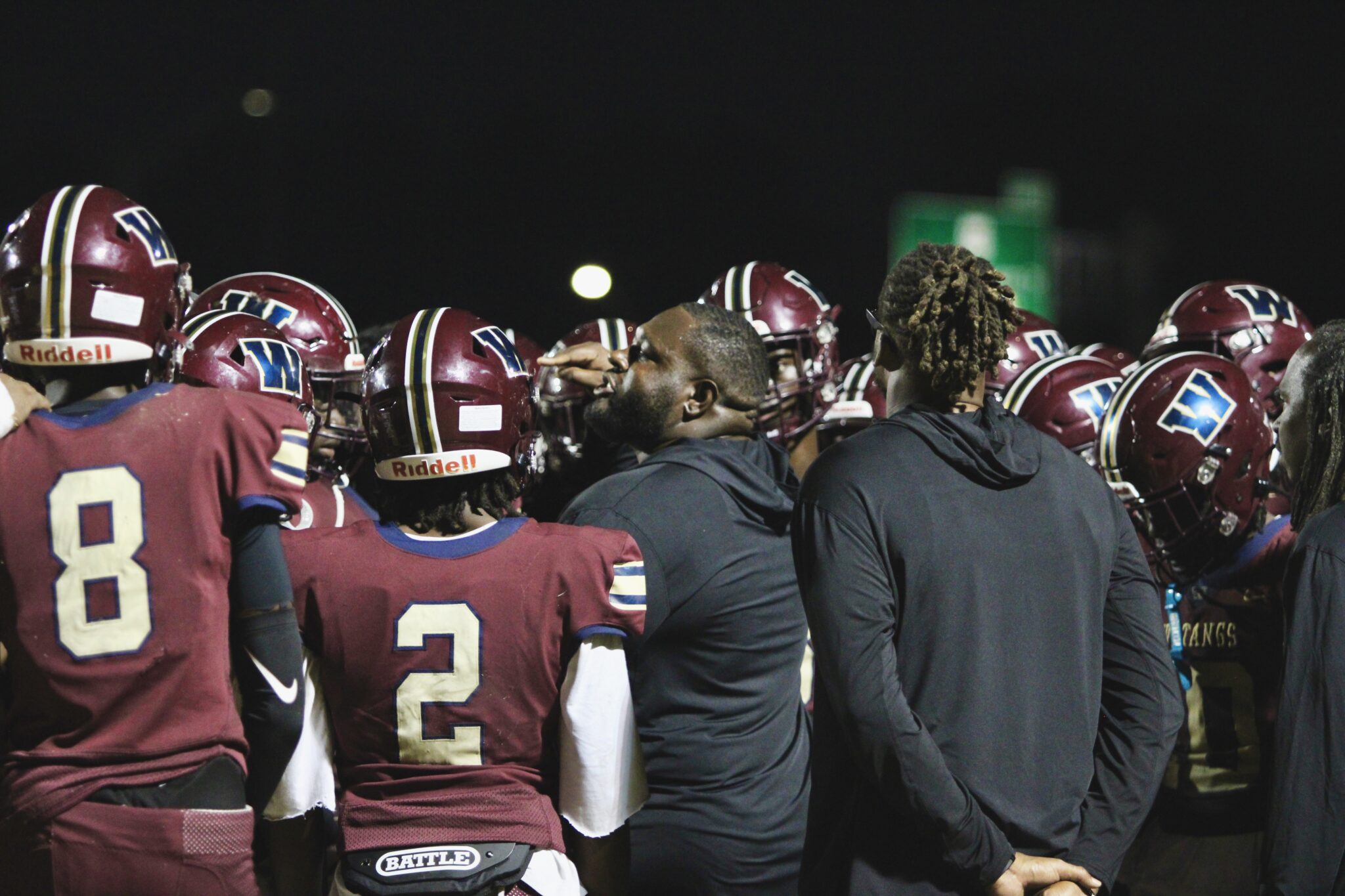 Coach Watts gathers the entire team during game against Horizon and voices stern motivation.