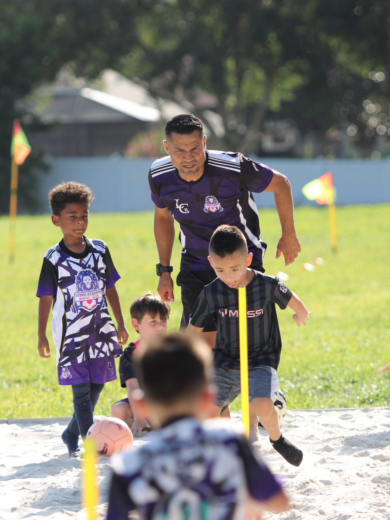 Coach and Club owner Carlos Longa watches his young athlete dribble through a drill.