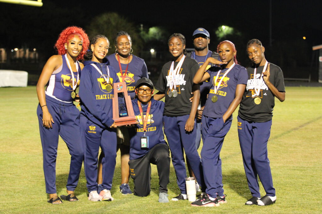 Lady Mustangs Track and Field poses with Regional trophy