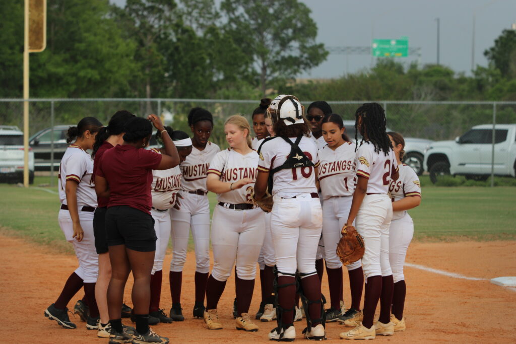 Lady Mustangs huddle up after coming in from the field