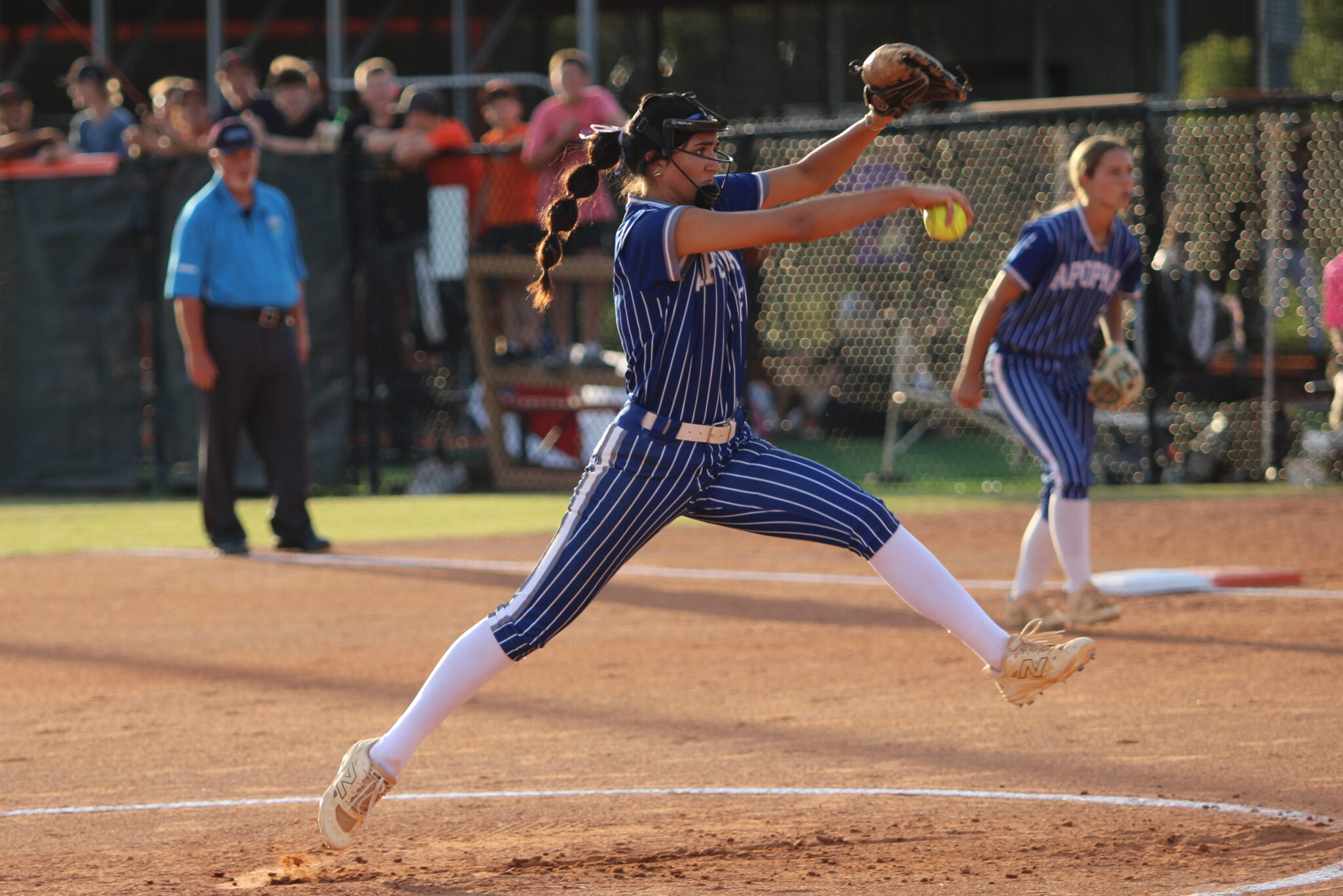Mia Aeschilman hovers over the dirt as she prepares to release a pitch in the first inning