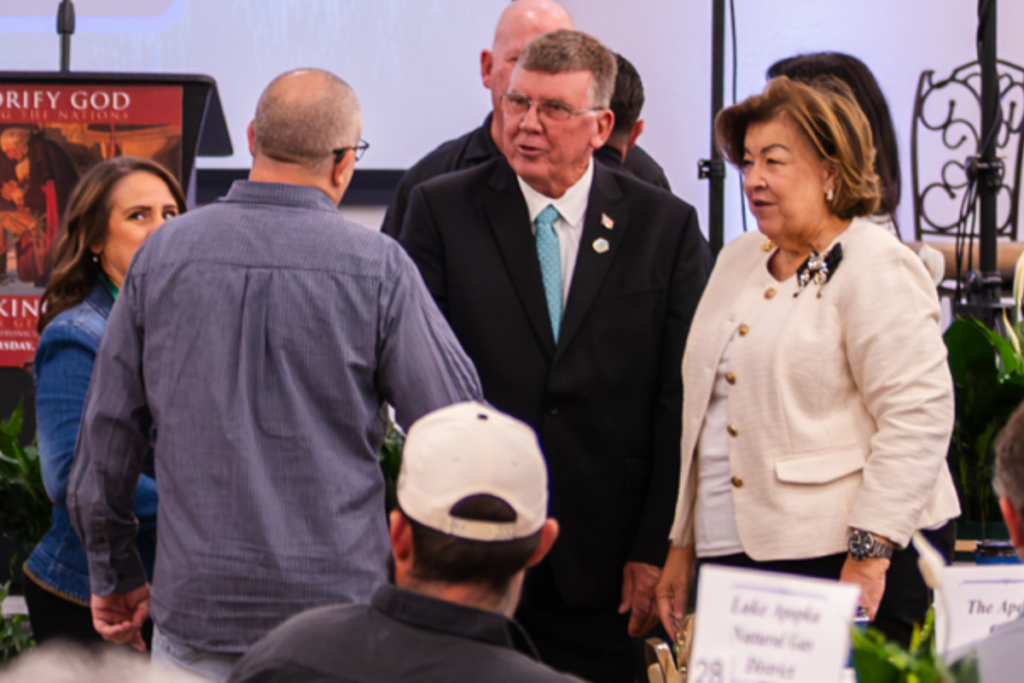 City Commissioner Sam Ruth (center), seen with Vice Mayor Diane Velazquez speaking with an attendee at the May 7 Apopka Mayor’s Prayer Breakfast, has called for revisiting the city’s Planning Commission structure.