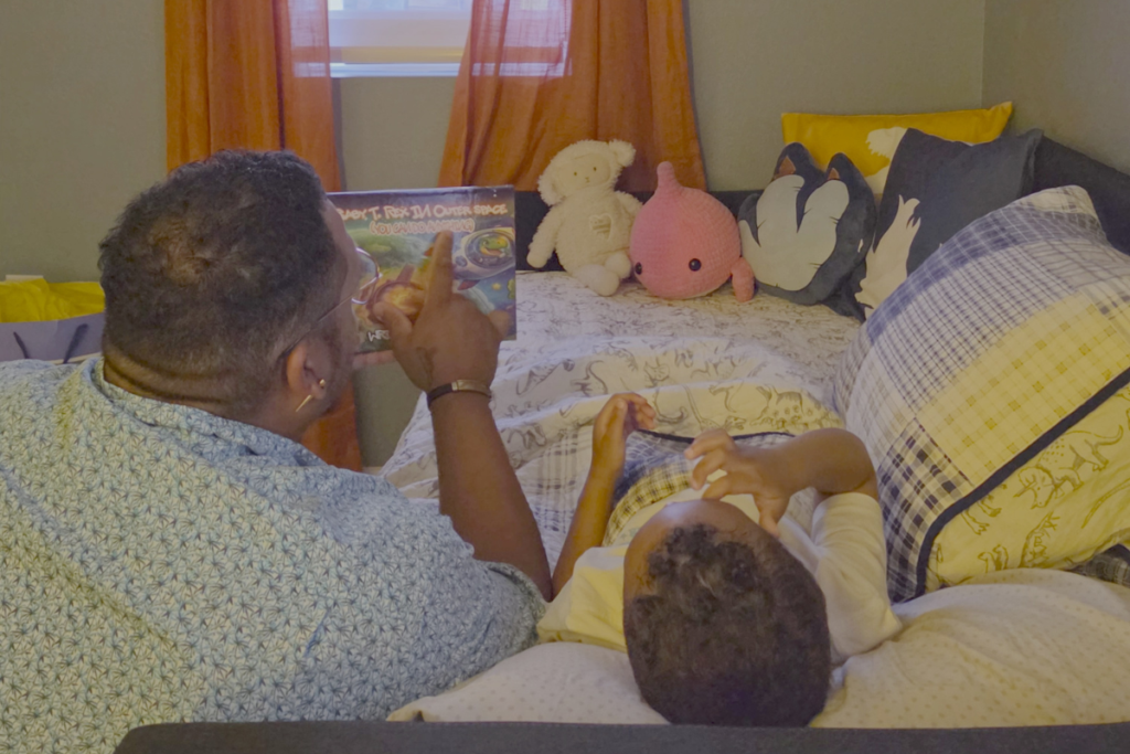 Daniel Turnage reads his new book to his son.