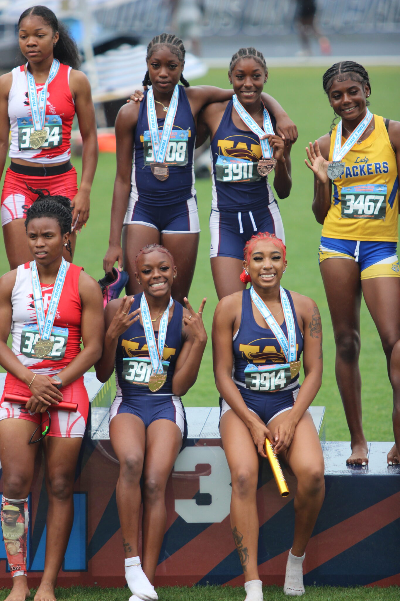 Wekiva 4x100m girls relay team flashes their bronze medals at the podium